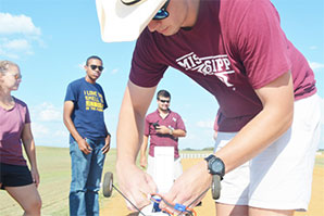 Student connects battery on drone